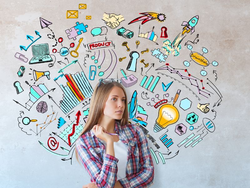 Une jeune femme réflechit devant un mur pleins de symboles dessines illustrant des graphismes ampoules puzzle fusee